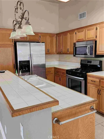 a kitchen with stainless steel appliances kitchen island granite countertop a stove and a sink