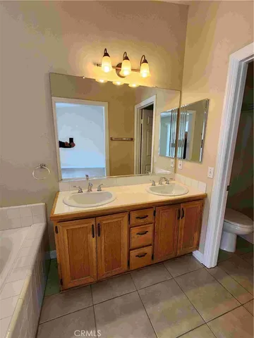 a spacious bathroom with a granite countertop sink and a mirror