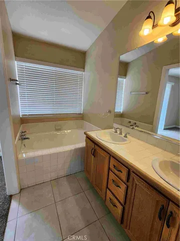 a bathroom with a granite countertop bathtub sink vanity and mirror