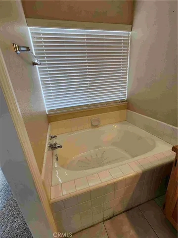 a bath tub sitting in a bathroom next to a window