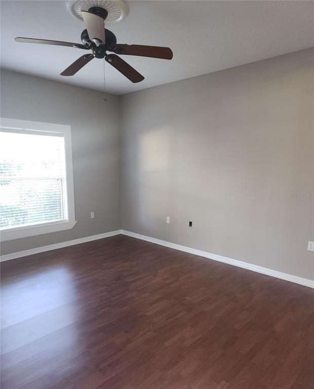 10969 Southwest 45th Avenue Ocala, FL 34476 - Photo 13 of 18 an empty room with wooden floor fan and windows