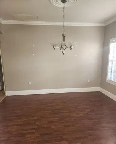 a view of an empty room with wooden floor closet and a window