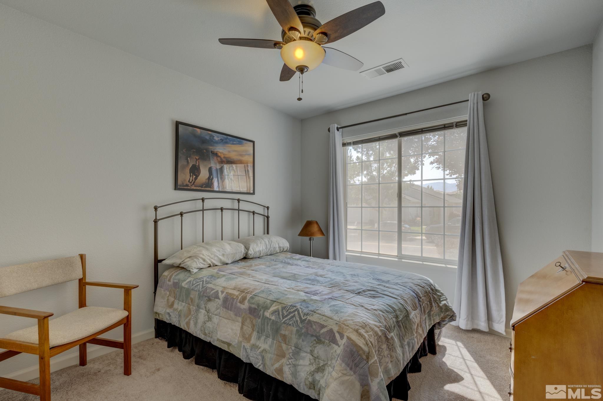 10695 Vista Bonita Lane Reno, NV 89521 - Photo 15 of 31 a bedroom with a bed and a chandelier