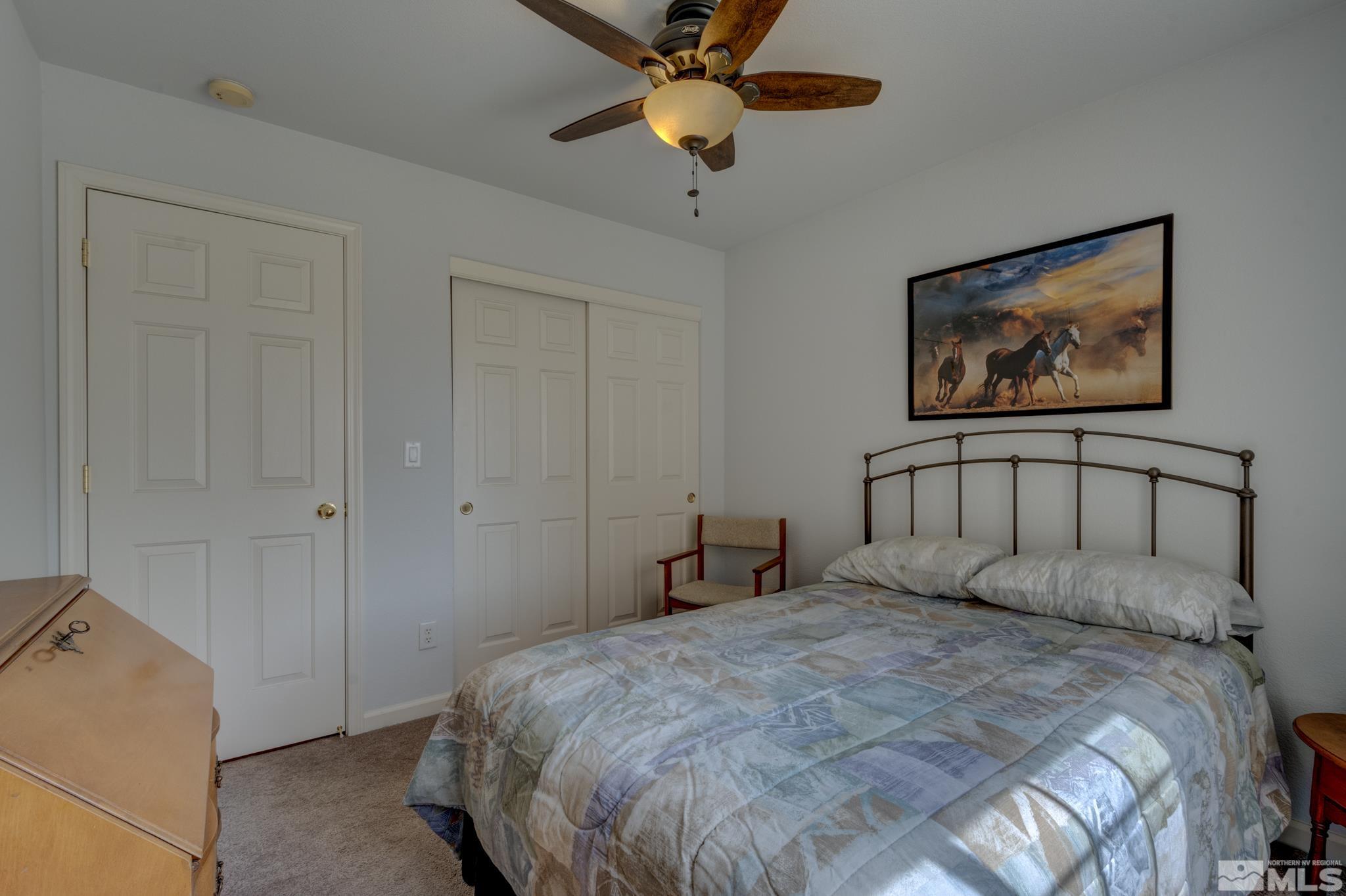 10695 Vista Bonita Lane Reno, NV 89521 - Photo 16 of 31 a bedroom with a bed and a chandelier