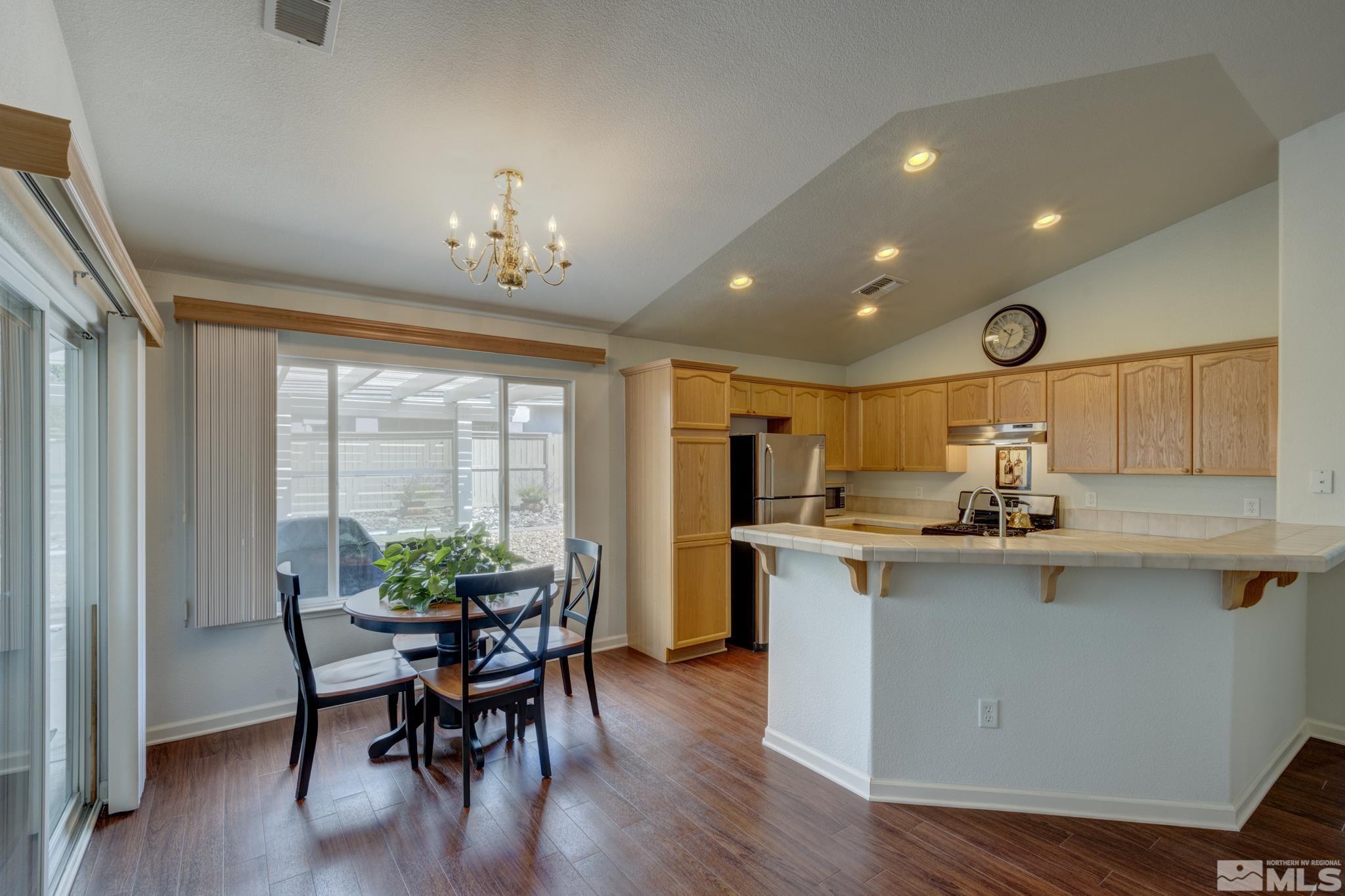 10695 Vista Bonita Lane Reno, NV 89521 - Photo 7 of 31 a kitchen with stainless steel appliances a dining table chairs and wooden floor