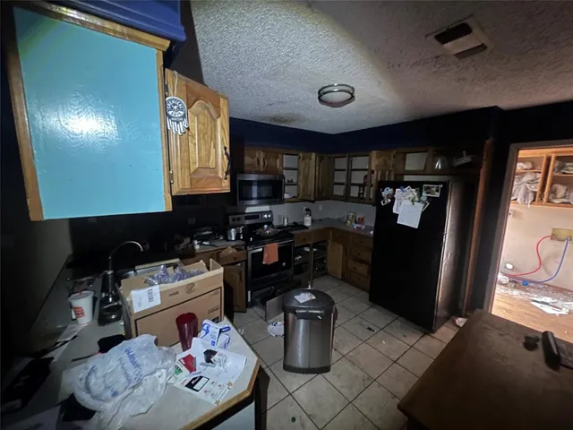 a kitchen with a refrigerator and a stove top oven