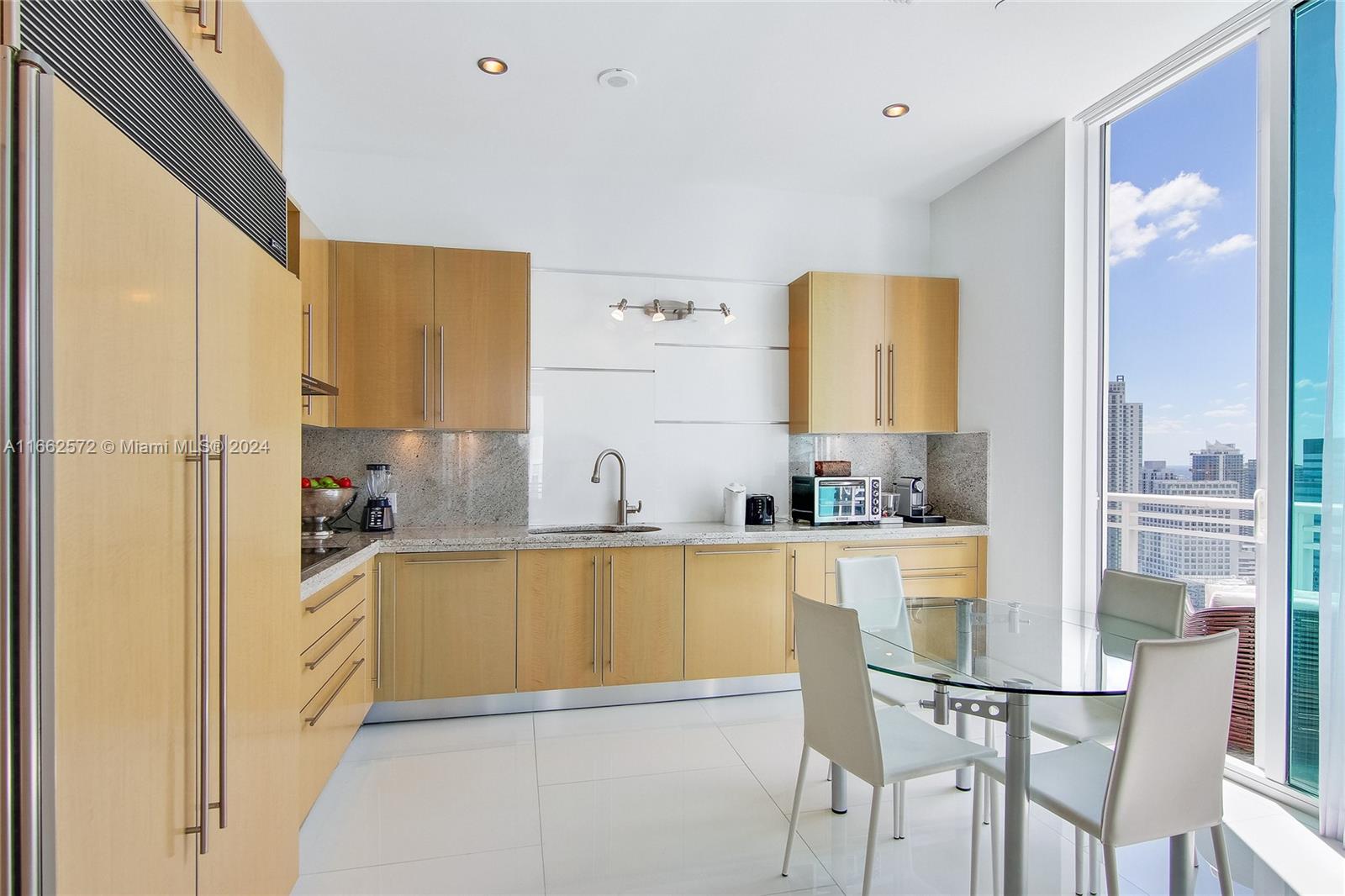 900 Brickell Key Boulevard, Unit PH3401 Miami, FL 33131 - Photo 15 of 58 a kitchen with stainless steel appliances granite countertop a refrigerator and a stove top oven