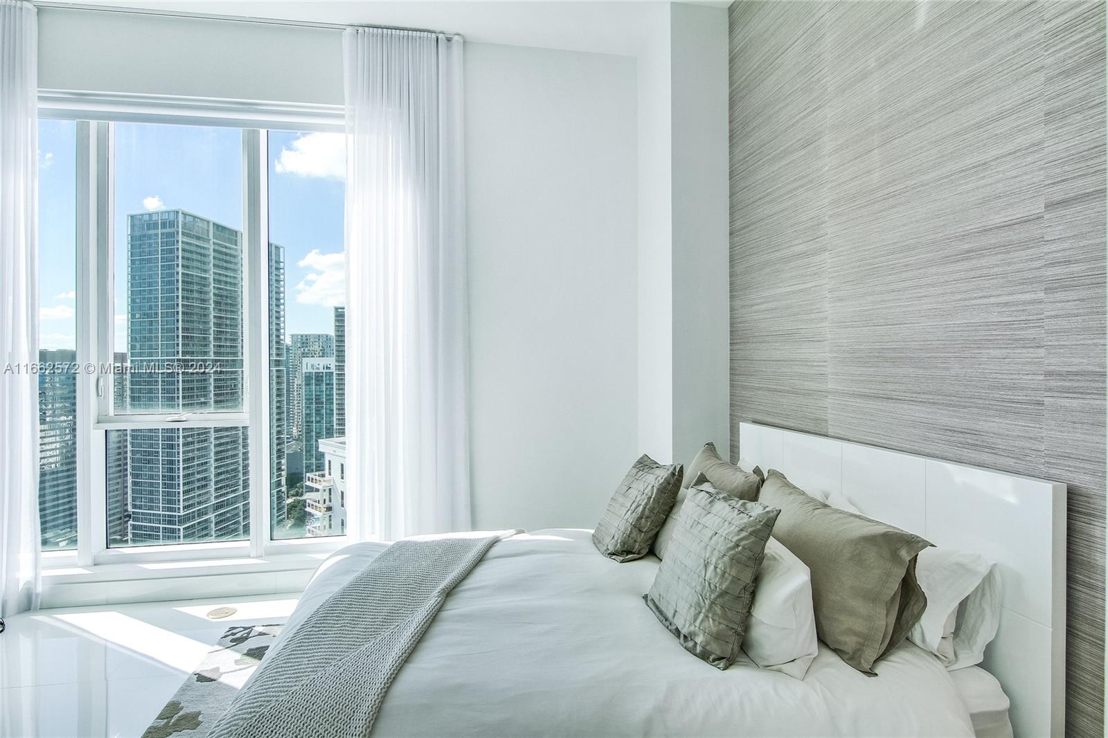 900 Brickell Key Boulevard, Unit PH3401 Miami, FL 33131 - Photo 28 of 58 a bed sitting in a bedroom next to a window