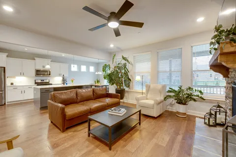 a living room with furniture kitchen view and a chandelier