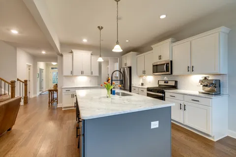 a large kitchen with stainless steel appliances kitchen island a large counter top
