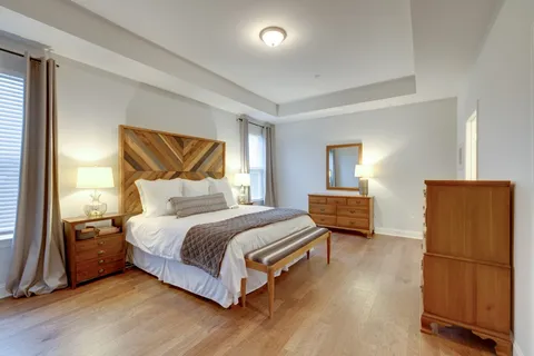 a bedroom with a bed and wooden floor