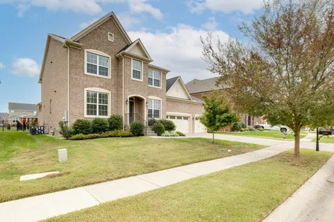 a front view of a house with a yard and trees