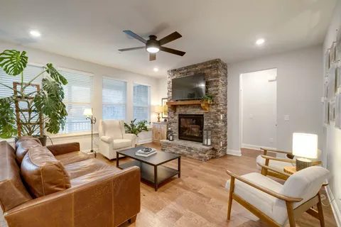 a living room with furniture kitchen view and a large window