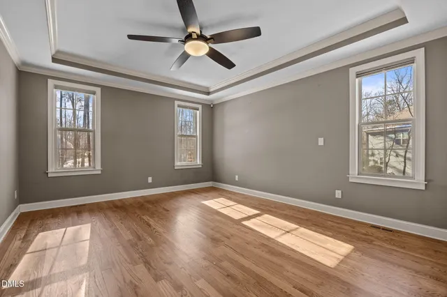 a view of an empty room with window and a ceiling fan