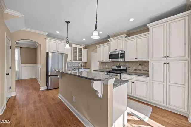 a kitchen with stainless steel appliances granite countertop a refrigerator a oven a stove and a sink