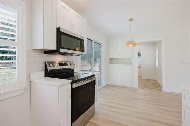 a kitchen with granite countertop a refrigerator stove top oven and sink