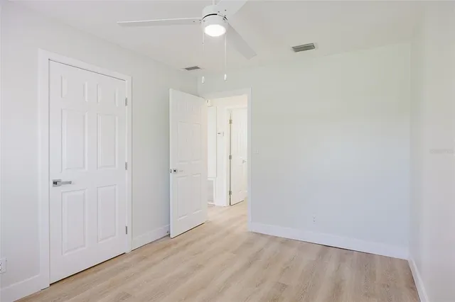a view of a hallway with wooden floor and closet
