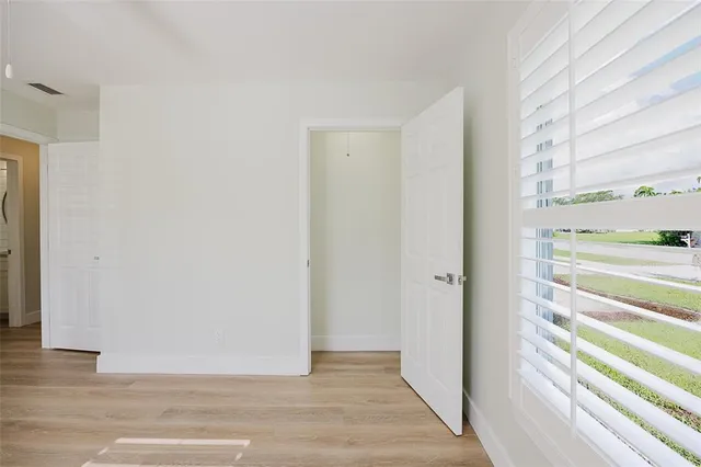 an empty room with windows and closet