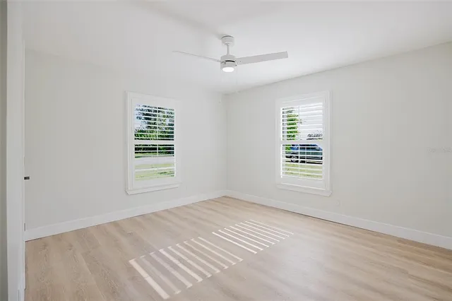 a view of a house with a yard and palm trees