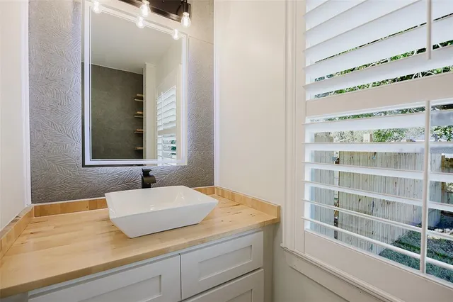 a view of a house with a yard potted plants and a bench