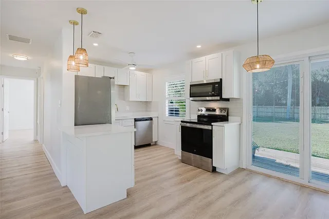 a kitchen with white cabinets and stainless steel appliances