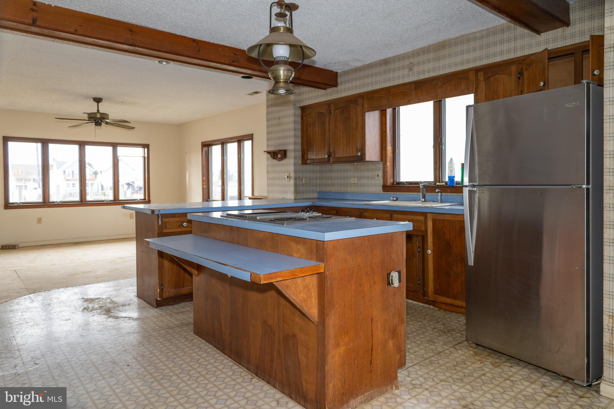 4404 South Bowers Road Milford, DE 19963 - Photo 18 of 53 a kitchen with stainless steel appliances granite countertop a refrigerator a sink dishwasher a stove and a dining table with wooden floor