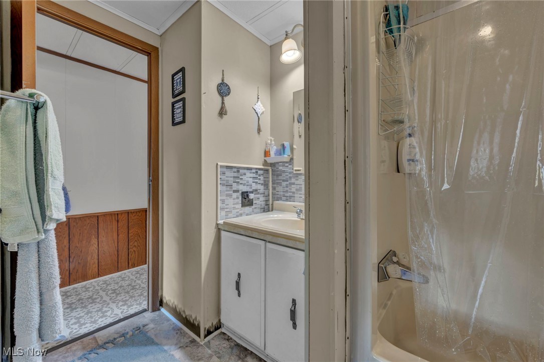 35157 Center Ridge Road, Unit 126 North Ridgeville, OH 44039 - Photo 48 of 50 Bathroom featuring vanity, tasteful backsplash, shower / bath combination with curtain, ornamental molding, and wainscoting