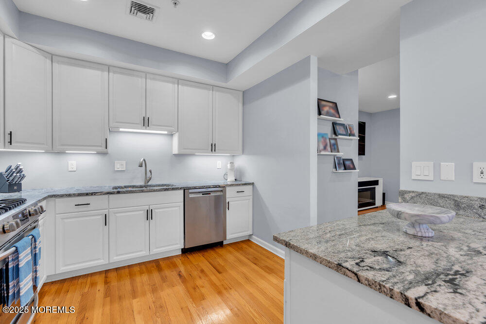 162 Main Street Manasquan, NJ 08736 - Photo 13 of 52 a kitchen with stainless steel appliances granite countertop a sink stove and cabinets