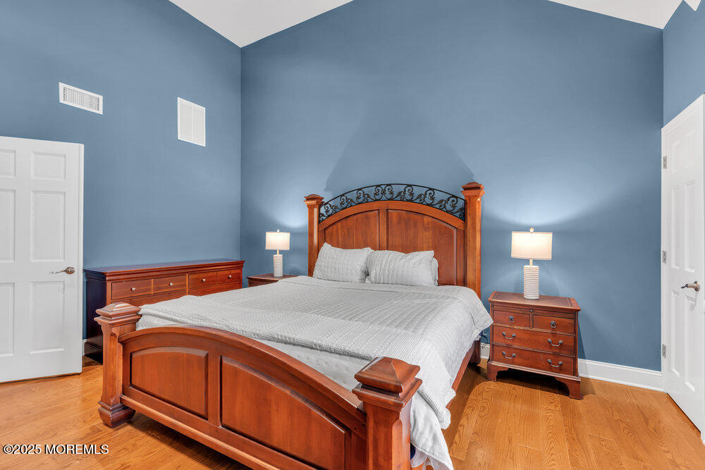 162 Main Street Manasquan, NJ 08736 - Photo 29 of 52 a bedroom with a bed and a painting on the wall