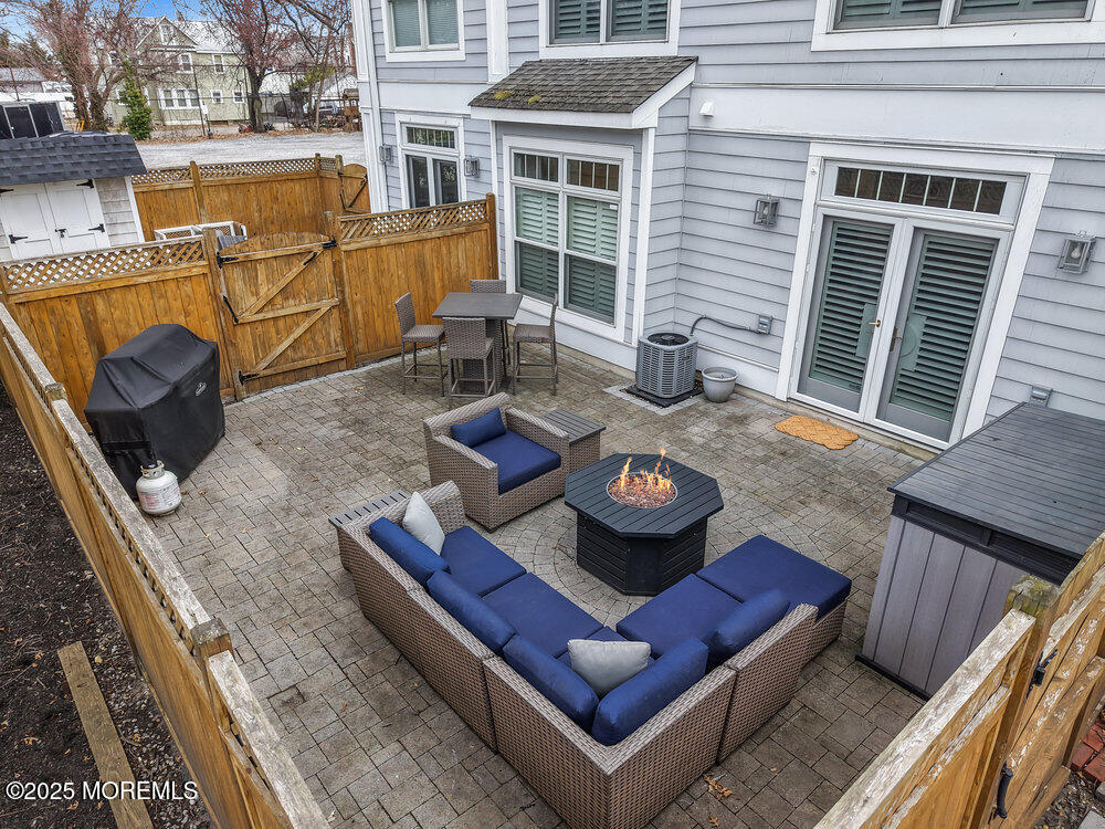 162 Main Street Manasquan, NJ 08736 - Photo 36 of 52 a view of a deck with couches table and chairs with wooden floor and fence