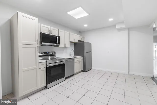 a kitchen with a refrigerator and a stove top oven