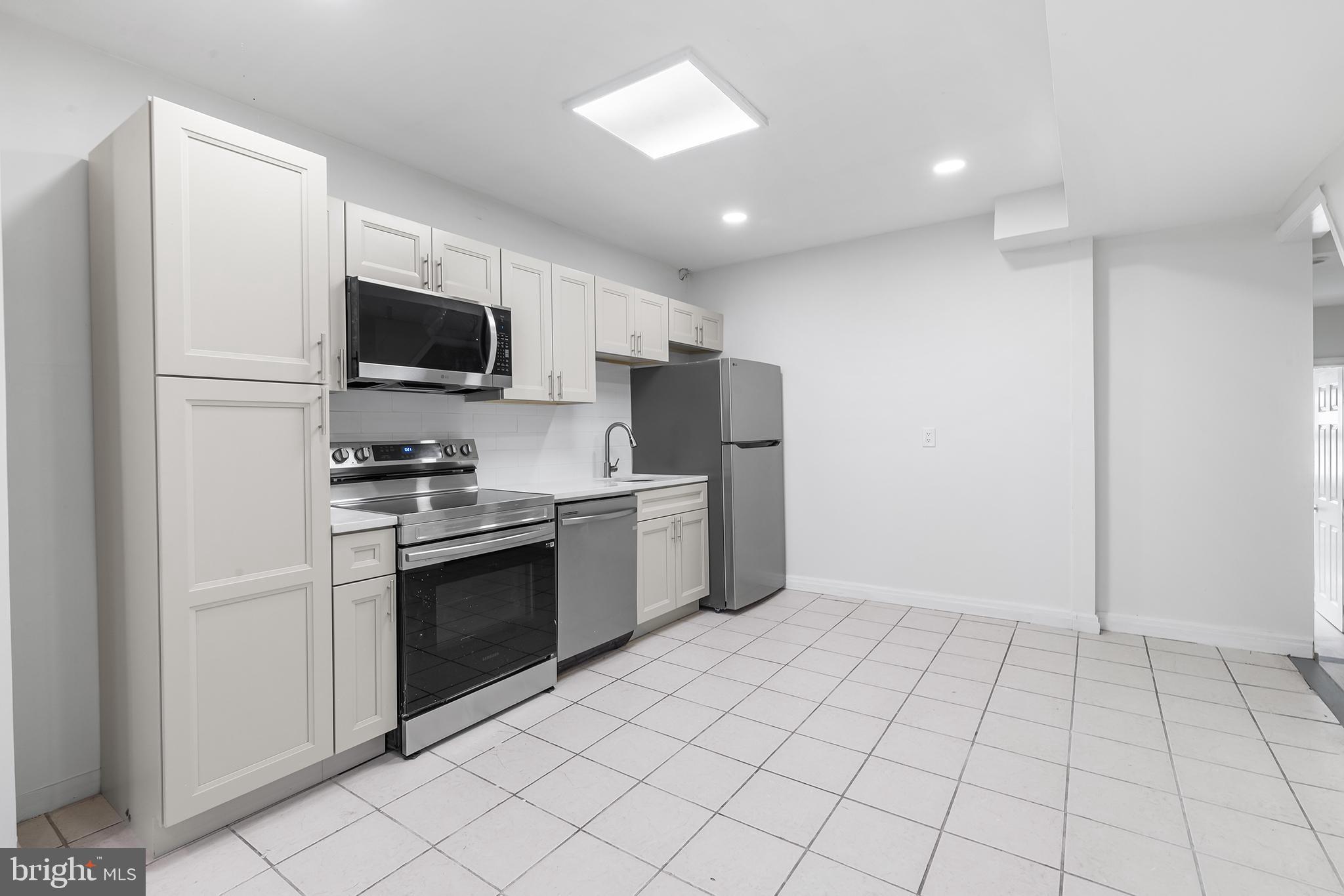 2120 Christian Street, Unit 2 Philadelphia, PA 19146 - Photo 2 of 10 a kitchen with a refrigerator and a stove top oven