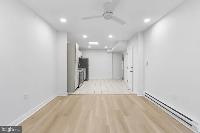 wooden floor in an empty room with a kitchen