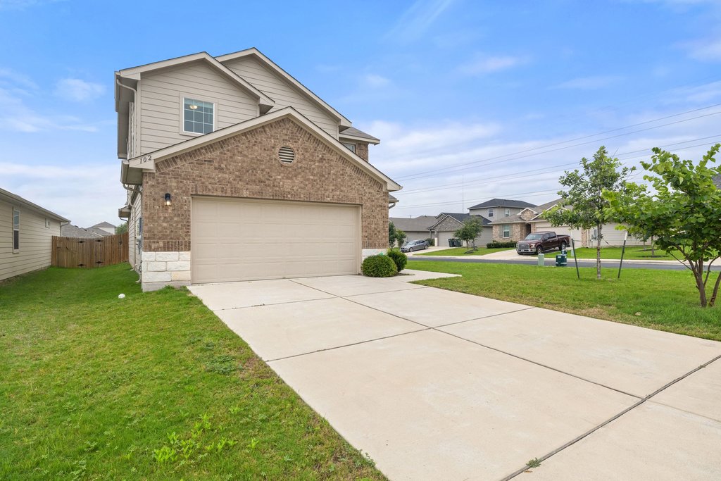 102 Ashford Way Georgetown, TX 78626 - Photo 2 of 28 A charming exterior welcomes with brick and siding, featuring a neatly paved driveway leading to the integrated garage.