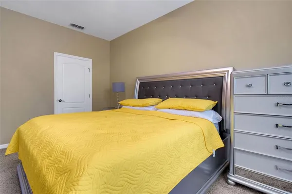 a bed sitting in a bedroom and a night stand