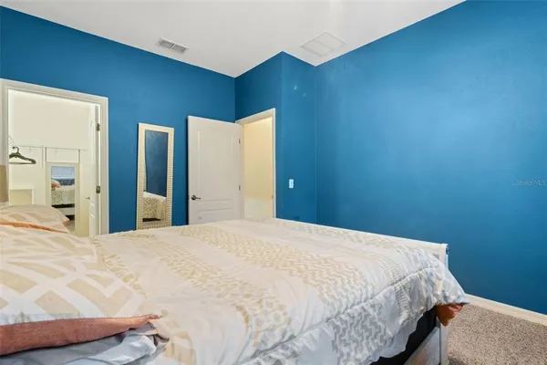 a bed sitting in a spacious bedroom next to a bathroom