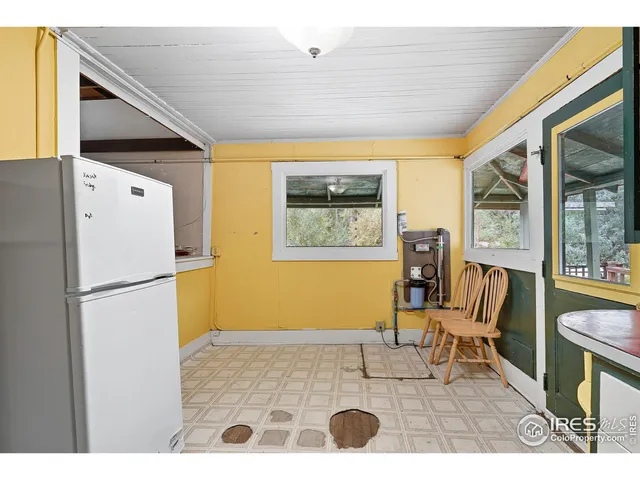 a view of kitchen with furniture and a refrigerator