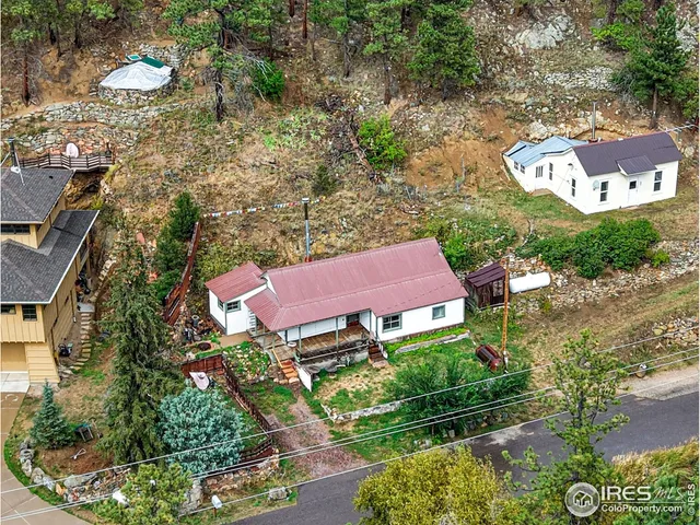 an aerial view of a house with a yard and lake view