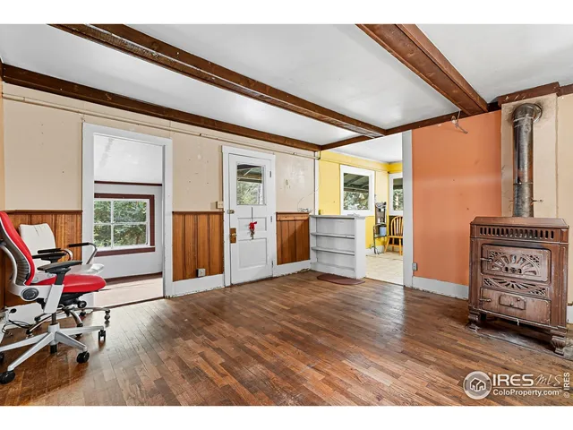 a view of an empty room with furniture and windows
