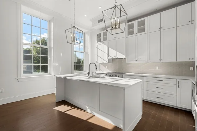 a kitchen with stainless steel appliances granite countertop a sink a stove and a window