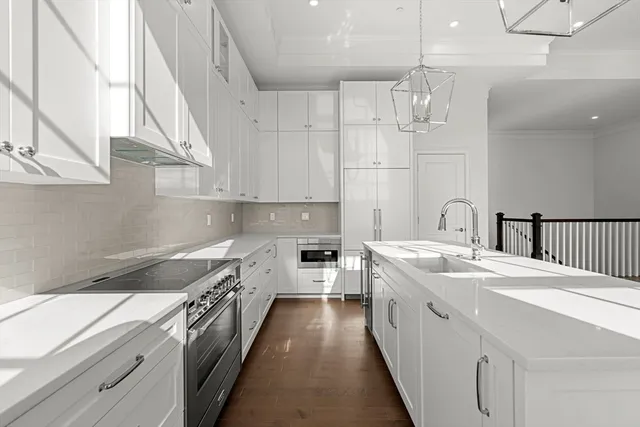 a kitchen with a sink a stove top oven and cabinets