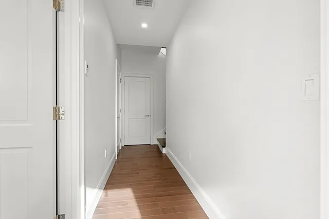 a view of a hallway with wooden floor
