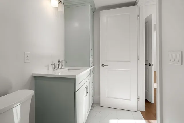 a bathroom with a sink and mirror with toilet