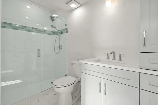 a bathroom with a sink a toilet and shower