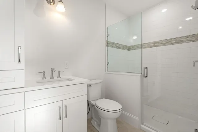 a bathroom with a sink a toilet and shower