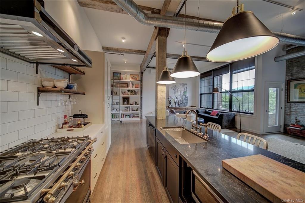 a kitchen with stainless steel appliances granite countertop a stove and a large window