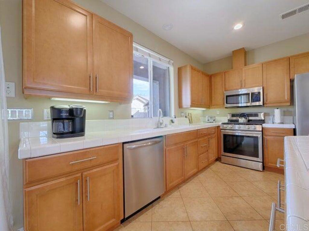 80596 Key Largo Avenue Indio, CA 92201 - Photo 10 of 59 a kitchen with granite countertop white cabinets stainless steel appliances and a sink