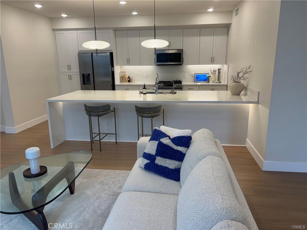 16175 Dawn Way, Unit 108 Tustin, CA 92782 - Photo 2 of 12 a kitchen with stainless steel appliances granite countertop a stove a sink a refrigerator and a fireplace