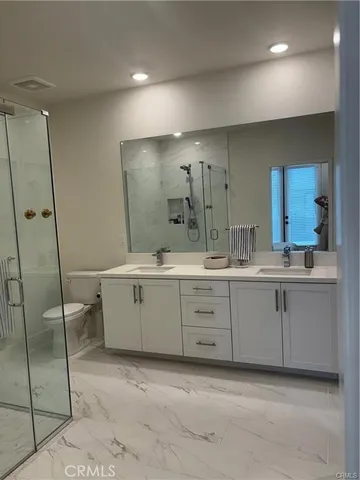 a bathroom with a double vanity sink mirror and toilet