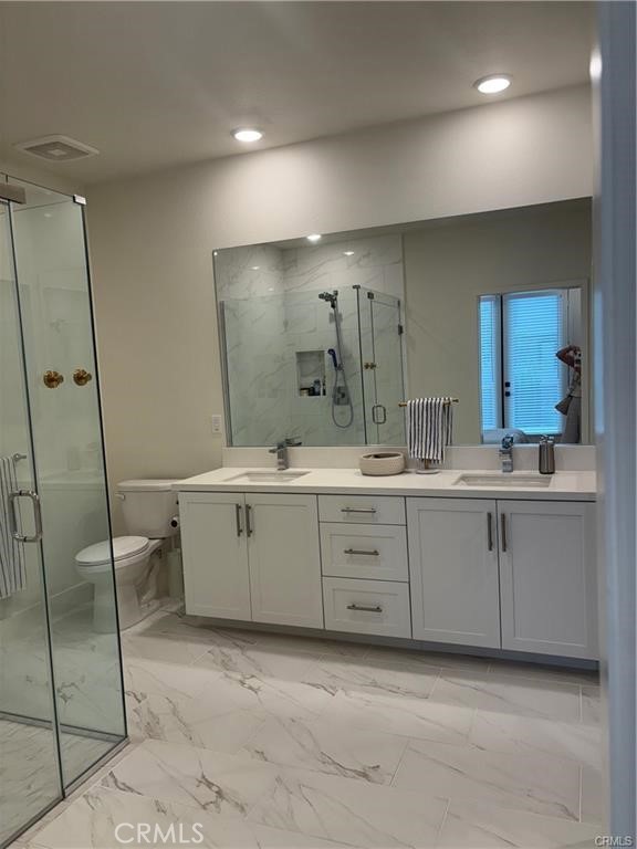 16175 Dawn Way, Unit 108 Tustin, CA 92782 - Photo 6 of 12 a bathroom with a double vanity sink mirror and toilet